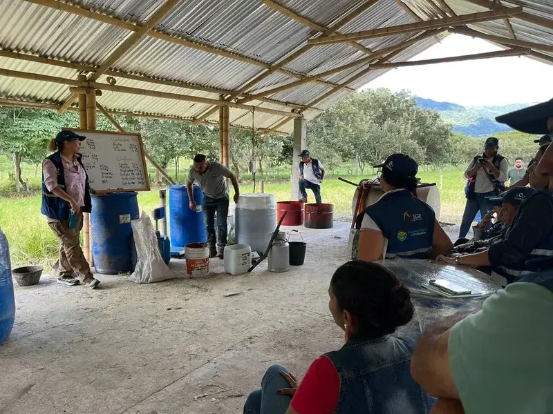 Grupo del curso de biofábricas preparando bioinsumos bajo el cobertizo