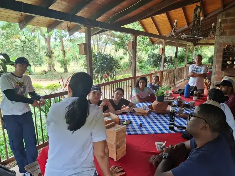 Instructor mostrando una caja de abejas meliponini al grupo del curso